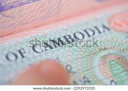 close-up part of page of document, foreign passport for travel with Cambodia visa, tourist visa stamp with hologram with shallow depth of field, passport control at border, travel in Southeast Asia
