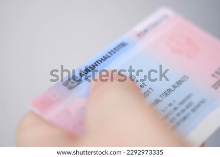 identity card, residence permit, personal document in female hand close-up with shallow depth of field, electronic communication in Europe, migration law, passport control at border, foreign travel Royalty-Free Stock Photo #2292973335