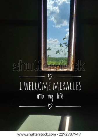 I welcome miracles into my life text on natural landscape background from window in dark room