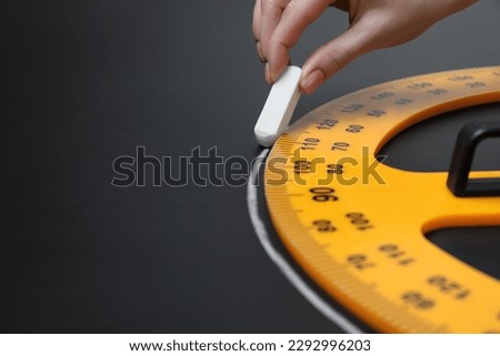 Woman drawing with chalk and protractor on blackboard, closeup. Space for text