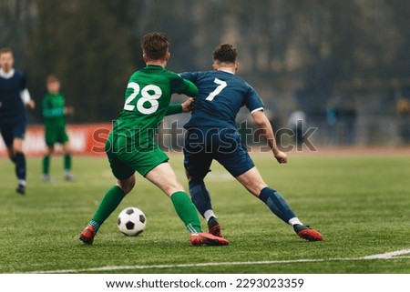 Two College Soccer Teams Playing Soccer League Game. Adult Soccer Players in a Duel. Two Football Players Competing in a Game. European Soccer Tournament Match For Adult Players. 