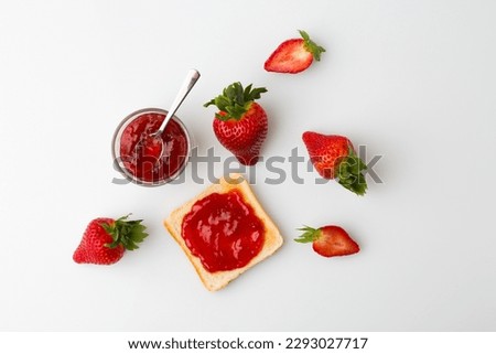 A top view of the strawberry jam-filled bread and strawberry fruit on a white background Royalty-Free Stock Photo #2293027717