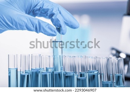 chemist,scientist hand pick up test tube from rack in laboratory background, science research and development concept