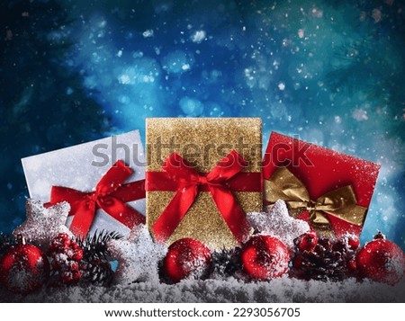 Red Christmas balls, stars and presents on snow