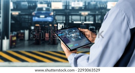 Smart Car Service Diagnostics Software concept.Mechanic using digital tablet Inspecting the Vehicle Royalty-Free Stock Photo #2293063529