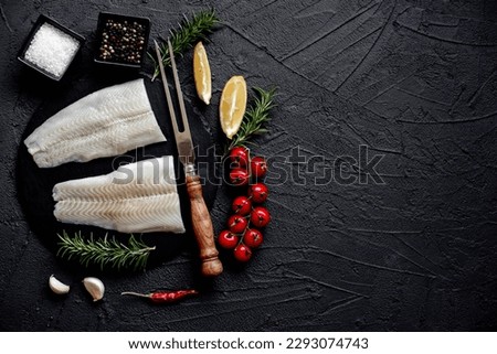 Fresh raw fillet of white fish Pangasius with spices on a stone background with copy space for your text