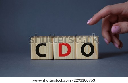 CDO - Collateralized Debt Obligation symbol. Wooden cubes with word CDO. Beautiful grey background. Businessman hand. Business and Collateralized Debt Obligation concept. Copy space.