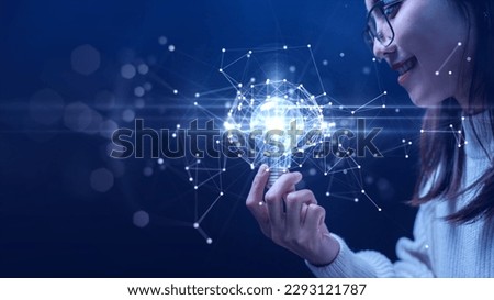 Businesswoman holding a light bulb illuminates the connection of polygons on the internet network. Futuristic technology on blue background Inspire to find innovation and develop marketing strategies.