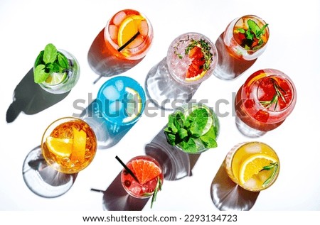 Summer cocktails drinks set. Assortment of multicolored strong and low alcoholic beverages for cocktail party. White background, hard light, shadows pattern, top view Royalty-Free Stock Photo #2293134723
