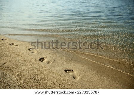 Feet and footprints by the seashore in nature travel vacation background