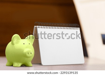 Blank office desk calendar and piggy bank