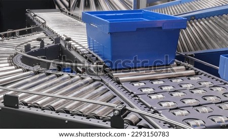 Crossing of the roller conveyor with plastic boxes, Production line conveyor roller transportation objects Royalty-Free Stock Photo #2293150783