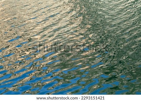 Moving river water in the foreground. Beautiful blue water pattern.