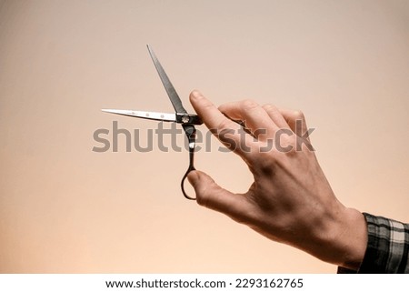 Close-up of barber male hand accurate holding scissors. Barber professional tools. Barber shop. Male hand holds hairdresser scissors Royalty-Free Stock Photo #2293162765