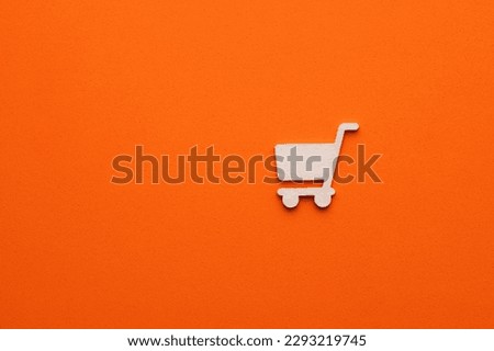 White supermarket car on orange background - symbol for website design or logo