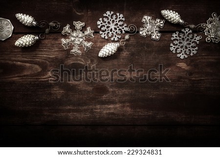Silver snowflake Christmas ornament border on a wooden background
