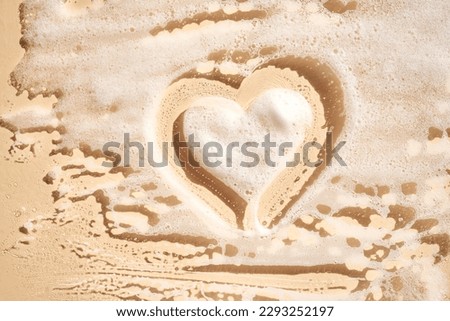 Photo of cosmetic foam or soap with a heart drawn on the foam.