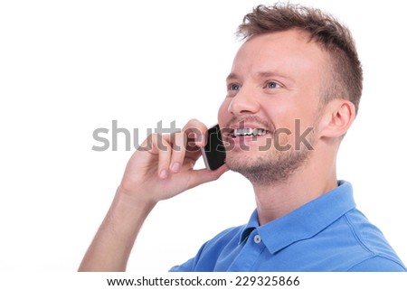 close up picture of a young casual man talking on the phone and smiling while looking away from the camera. isolated on a white background