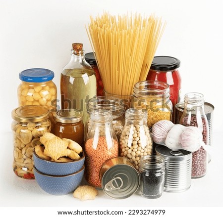 Food supplies crisis food stock. Different glass jars with grains, pasta, cans of canned food on  white background. 
