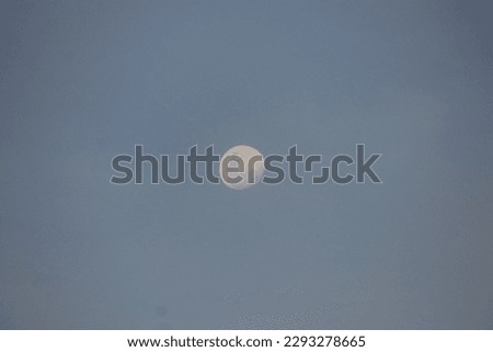 Photo of the moon from earth against a blue sky background