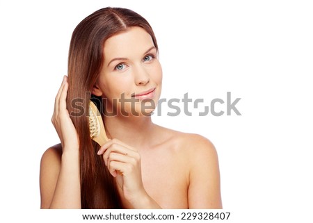 Gorgeous woman brushing her hair with hairbrush