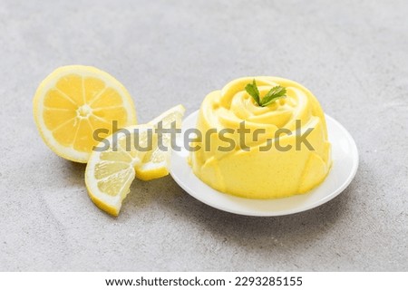 Vegan Lemon cream pudding, Panna Cotta in the shape of a rose, on a plate. Light grey background