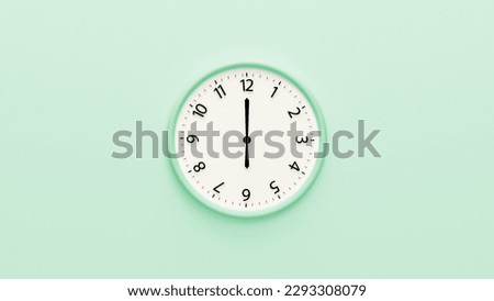 White clock on pastel color background. White wall clock hanging on the wall. Minimalist flat lay image of plastic wall clock over color background. Copy space. 6 o'clock