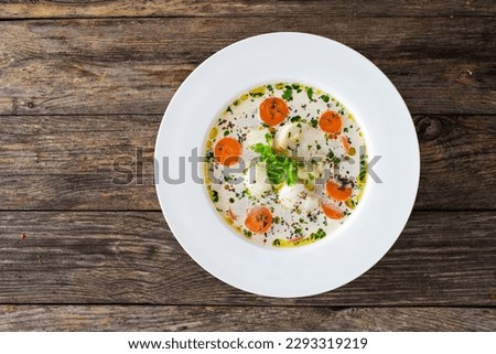 Fish soup on wooden table 