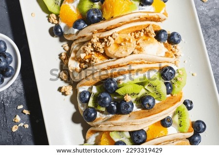 Taco Pancakes with Fresh Fruits, Blueberry and Yogurt Filling, Healthy Breakfast or Snack on Dark Background