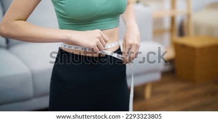 Asian woman with anorexia  with measuring tape feeling unhappy. Anorexia problem body perception and dysmorphia conceptใ Royalty-Free Stock Photo #2293323805