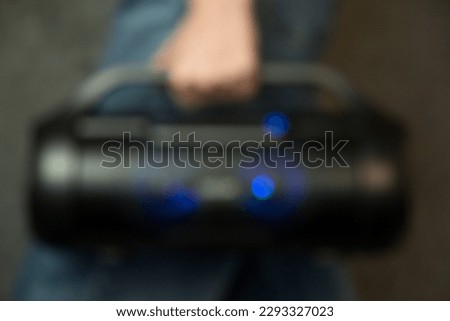 Portable music column in hand. Blurred background. High quality photo