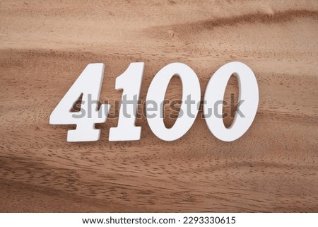 White number 4100 on a brown and light brown wooden background.