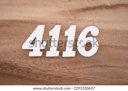 White number 4116 on a brown and light brown wooden background.