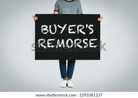 Woman holding poster with text Buyer's Remorse on light grey background, closeup Royalty-Free Stock Photo #2293381237