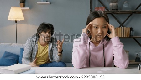 Emotional annoyed stressed couple sitting on couch, arguing at home. Angry irritated nervous woman man shouting at each other, figuring out relations, feeling outraged, relationship problems concept. Royalty-Free Stock Photo #2293388155