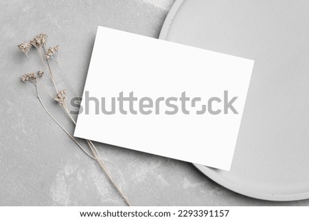 Invitation or greeting card mockup with gypsophila flowers, blank card flat lay with copy space on grey