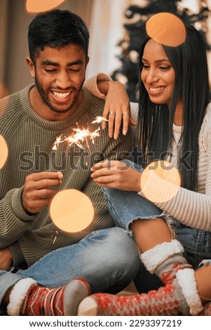 Keep calm and jingle all the way. a young couple holding sparklers while celebrating Christmas together at home.