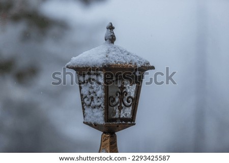 December 2022,Murree Pakistan,a brown coloured street light lamp covered with seasons first snowfall Royalty-Free Stock Photo #2293425587