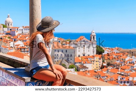 Woman tourist sitting on balcony looking at panoramic view of rooftop of Lisbon- Portugal Royalty-Free Stock Photo #2293427573
