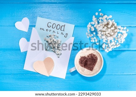 Coffee mug with bouquet of white flowers and notes Good morning on wooden table, beautiful spring breakfast concept, top view flatlay 