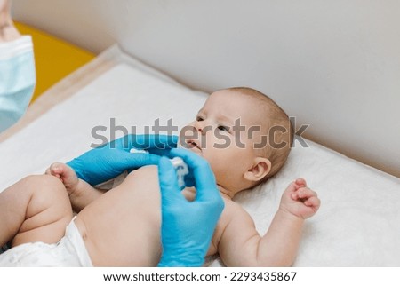 Pediatrician administring oral vaccination against rotavirus infection to little baby. Children health care and disease prevention.  Royalty-Free Stock Photo #2293435867