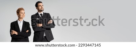 happy redhead businesswoman and confident businessman looking away isolated on grey, banner
