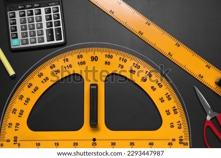 Flat lay composition with protractor and ruler on black table