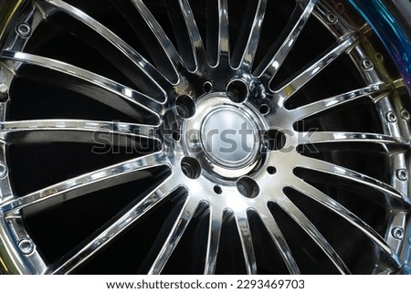 Beautiful aluminum die-cast disc wheel with thin chrome spokes for a 20 diameter car close-up on a black background Royalty-Free Stock Photo #2293469703