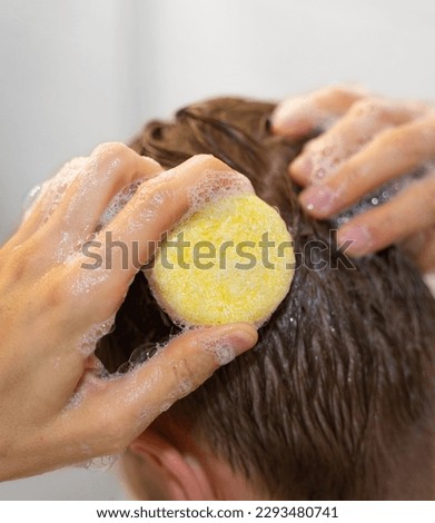 A man uses a solid shampoo bar in the bathroom. An applying shampoo to the scalp. Plastic free, zero waste living, low water ingredients. Sustainable hair care. Responsibility for the nature. Royalty-Free Stock Photo #2293480741