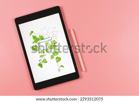 Top view or flat lay of digital tablet with picture of house plant in watercolor style on screen,  pink stylus pen,   isolated on pink  background. Digital art concept.