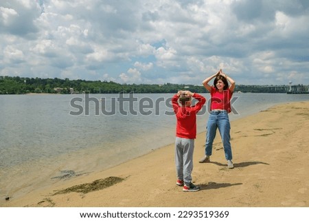 Mom and son doing gymnastics on the beach
