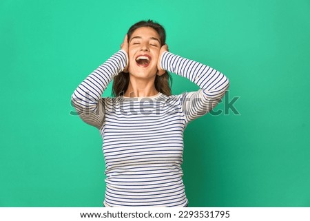 Young caucasian woman isolated laughs joyfully keeping hands on head. Happiness concept.