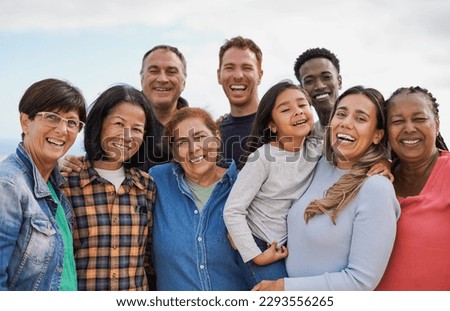 Group of multigenerational people hugging each other while smiling on camera - Multiracial friends having fun together outdoor Royalty-Free Stock Photo #2293556265