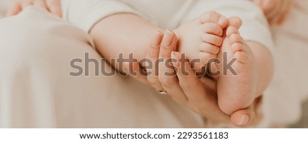 Banner. Mother holding in the hands feet of newborn baby. Baby feet in mother hands. Tiny Newborn Baby's feet on female Shaped hands closeup. Mom and her Child. Happy Family concept.  Royalty-Free Stock Photo #2293561183